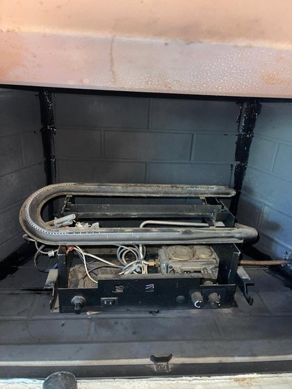 Gas log set lifted out so the burner and firebox can be cleaned